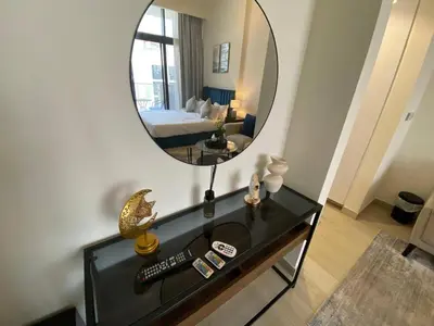a room with a bed and a mirror on a table at Modern Studio with Balcony - Pool View in Dubai