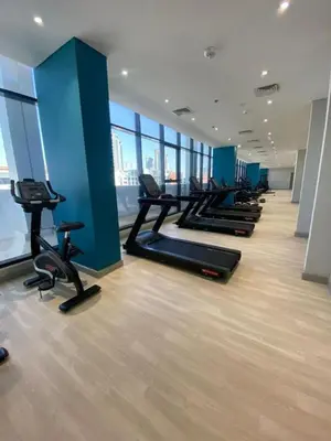 a gym with a row of treadmills and exercise bikes at Bright Studio - Azizi Riviera 35 - Fully Furnished in Dubai