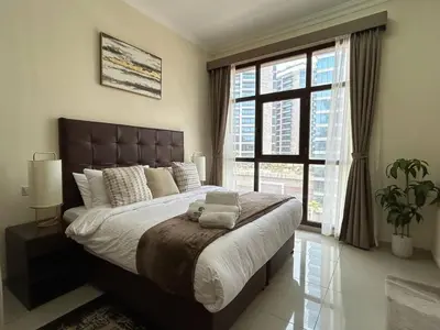 a bedroom with a large bed and a large window at Modern Studio - Lincoln Park West - Dubai, Arjan in Dubai