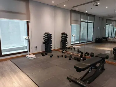 a gym with dumbbells and weights in a room at Modern Studio - Lincoln Park West - Dubai, Arjan in Dubai