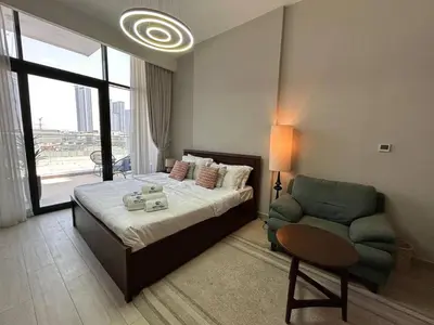 a bedroom with a bed and a couch and a chair at Stylish Studio Retreat, Meydan Area and Pool Access in Dubai