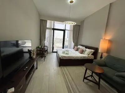 a living room with a bed and a couch at Stylish Studio Retreat, Meydan Area and Pool Access in Dubai