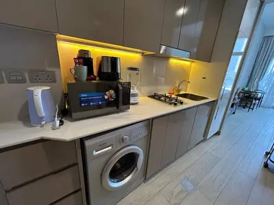 a kitchen with a washing machine on a counter at Stylish Studio Retreat, Meydan Area and Pool Access in Dubai