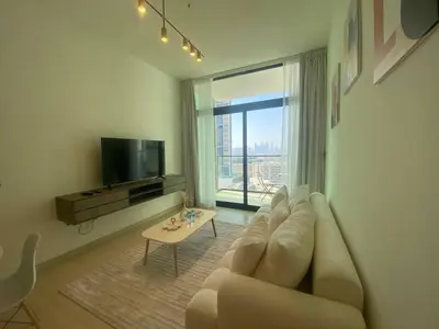 a living room with a couch and a tv and a table at 1-Bedroom in Binghatti Emerald 1 with free Pool and Gym in Dubai