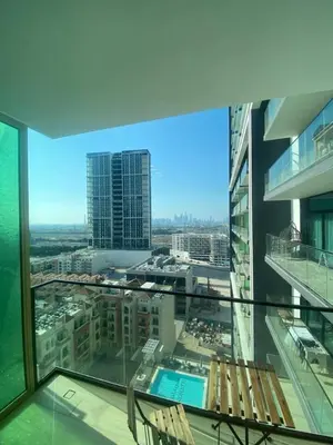 a balcony with chairs and a view of a city at 1-Bedroom in Binghatti Emerald 1 with free Pool and Gym in Dubai