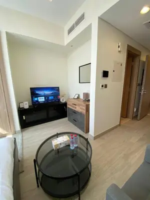 a living room with a coffee table and a tv at Modern Studio in Azizi Riviera 10, Near Downtown in Dubai