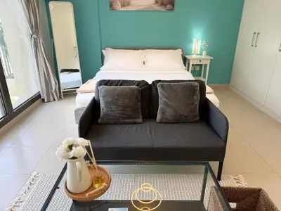 a living room with a couch and a bed at ASHRI HH | Elegant Studio | UNA Townsquare in Dubai
