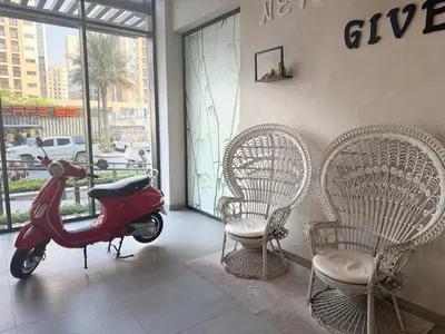 a scooter parked in a room with two chairs at ASHRI HH | Elegant Studio | UNA Townsquare in Dubai