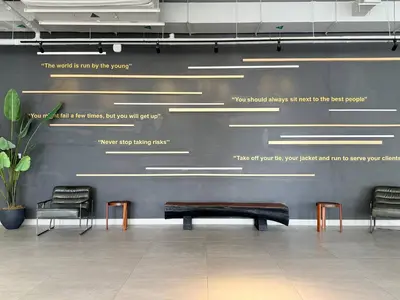 a bench in a waiting room with chairs and lights at ASHRI HH | Elegant Studio | UNA Townsquare in Dubai