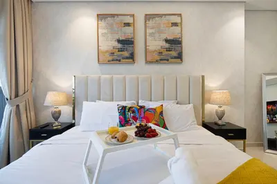 a white bed with a tray of fruit on it at Burj Khalifa View II Luxury HIGH Floor whith Pool&Spa in Dubai