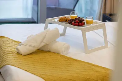 a bed with a tray of food and two glasses of orange juice at Burj Khalifa View II Luxury HIGH Floor whith Pool&Spa in Dubai