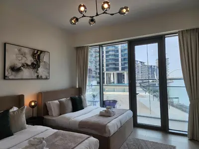 a hotel room with two beds and a large window at SOLARTE Luxe - NEW Canal Front Residence - Pool with Burj Views in Dubai