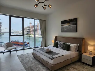 a bedroom with a large bed and a large window at SOLARTE Luxe - NEW Canal Front Residence - Pool with Burj Views in Dubai