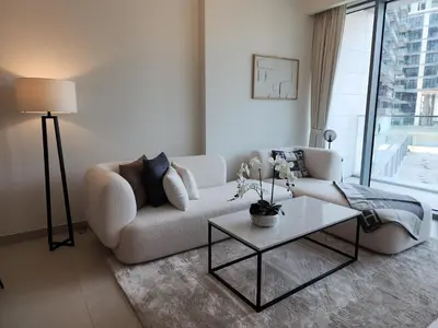 a living room with a white couch and a table at SOLARTE Luxe - NEW Canal Front Residence - Pool with Burj Views in Dubai