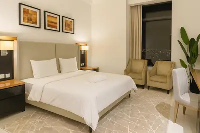 a hotel room with a bed and two chairs at Stylish Studio in Business Bay Walking to Canal and Downtown in Dubai
