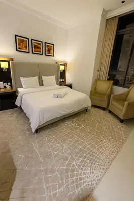 a bedroom with a large bed and a chair at Stylish Studio in Business Bay Walking to Canal and Downtown in Dubai