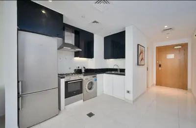 a kitchen with a washer and a sink and a dishwasher at Stylish Studio in Business Bay Walking to Canal and Downtown in Dubai