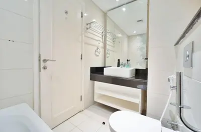 a white bathroom with a sink and a toilet at Stylish Studio in Business Bay Walking to Canal and Downtown in Dubai