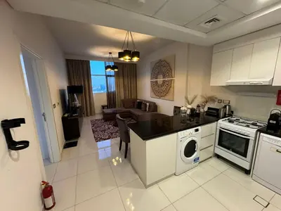 a kitchen and living room with a stove top oven at Premium 1BR Apartment In Damac Ghalia with City View & Balcony in Dubai