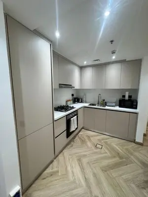 a kitchen with white cabinets and a wooden floor at Stylish 1BR in Dubai Marina,Walk to JBR in Dubai