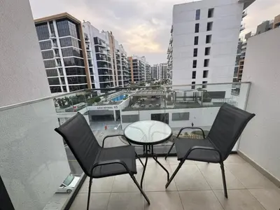 a balcony with two chairs and a table on a building at Azizi Riviera 41 - Meydan by Golden Casa in Dubai