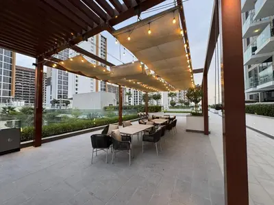 a patio with tables and chairs in a building at Azizi Riviera 41 - Meydan by Golden Casa in Dubai