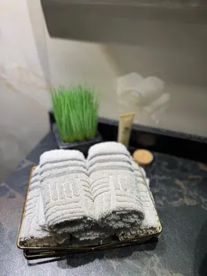 a stack of towels sitting on a tray with grass at Spacious 3BR Apartment Family Friendly Community in Dubai