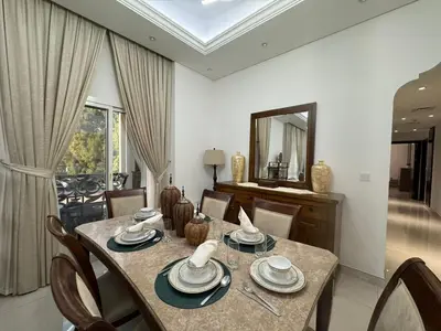 a dining room with a table and chairs and a mirror at Spacious 3BR Apartment Family Friendly Community in Dubai