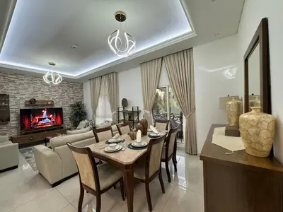a dining room and living room with a table and chairs at Spacious 3BR Apartment Family Friendly Community in Dubai