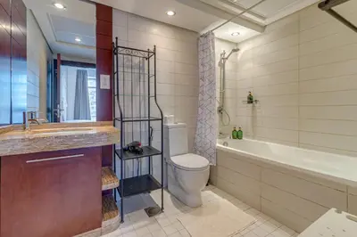 a bathroom with a toilet and a tub and a sink at Burj Views Tower, 1 Bdr Apartment with Opera View in Dubai