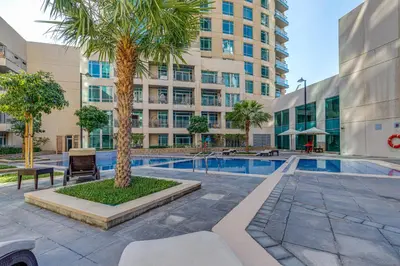 a courtyard with a palm tree in front of a building at Burj Views Tower, 1 Bdr Apartment with Opera View in Dubai