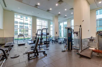 a gym with treadmills and machines in a building at Burj Views Tower, 1 Bdr Apartment with Opera View in Dubai
