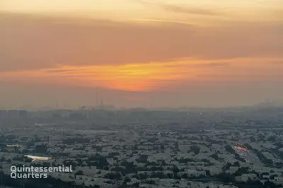 a view of a city with a sunset in the sky at Stylish & Peaceful 2BR Home in JVC District in Dubai
