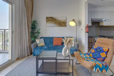 a living room with a blue couch and a table at Remraam, 1 Bedroom in Al Ramth 11 - Allsopp & Allsopp in Dubai