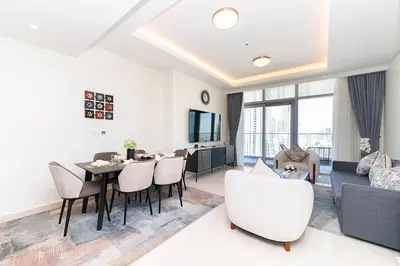 a living room with a table and chairs and a couch at Luxury 3BR Imperial Avenue Burj Khalifa Views in Dubai
