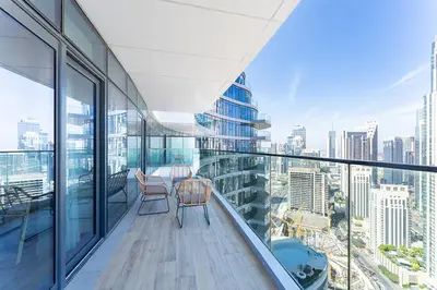 a balcony with a table and chairs on a building at Luxury 3BR Imperial Avenue Burj Khalifa Views in Dubai