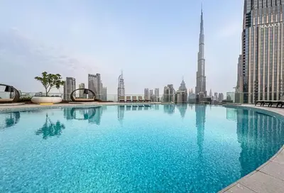 a large swimming pool with a view of a city at Luxury 3BR Imperial Avenue Burj Khalifa Views in Dubai