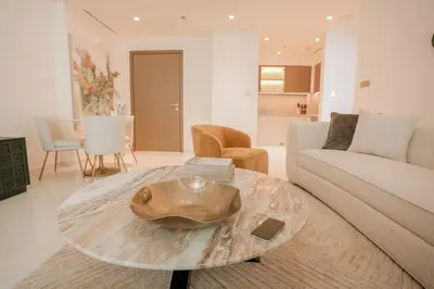 a living room with a table and a couch at Cozy Apartment with Private Beach & Palm Views in Dubai