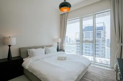 a bedroom with a large white bed and a large window at Cozy Apartment with Private Beach & Palm Views in Dubai
