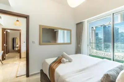 a bedroom with a bed and a large window at RH - Burj Khalifa view with large balcony, 02BR retreat in business bay in Dubai
