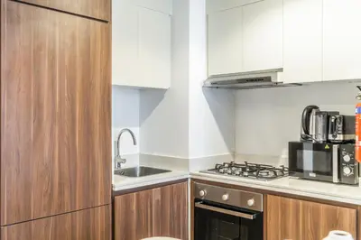 a small kitchen with a sink and a stove at RH - Burj Khalifa view with large balcony, 02BR retreat in business bay in Dubai