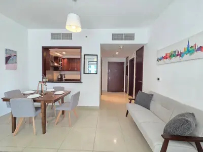 a living room with a table and a couch at Vacay Lettings 1 bed with burj Khalifa View in Dubai