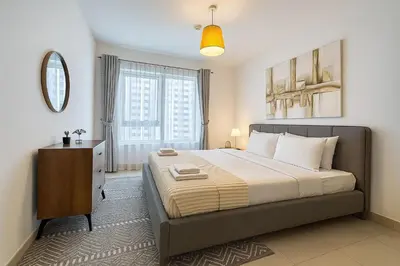 a bedroom with a large bed and a mirror at Vacay Lettings 1 bed with burj Khalifa View in Dubai