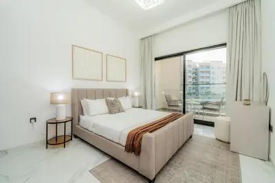a white bedroom with a bed and a large window at Gardenia Living 204 in Dubai