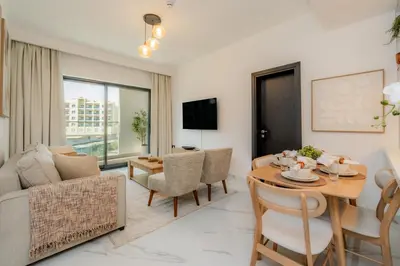 a living room with a couch and a table and chairs at Gardenia Living 204 in Dubai