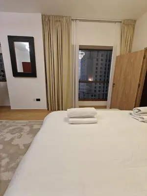 a bedroom with a large white bed with towels on it at 2 Massage Chairs Marina View 2 Bedrooms in Dubai