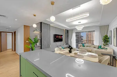 a kitchen and living room with a couch and a table at Gym, Spa & Sauna, Pool, Tenis Court, Dishwasher, 2BR in Central Park in Dubai