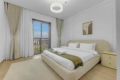a bedroom with a large bed and a large window at Gym, Spa & Sauna, Pool, Tenis Court, Dishwasher, 2BR in Central Park in Dubai