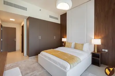 a bedroom with a large white bed and two lamps at Vogue JVC Jeewar Tower Near Circle Mall, One Bedroom Apartment with Balcony and City View, Access to all Amenities in Dubai