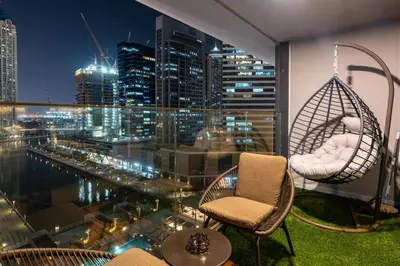 a balcony with chairs and a view of a city at Modern 1BR Canal View Pool View in Dubai